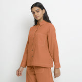 Left View of a Model wearing Vegetable Dyed Orange Button-Down Top