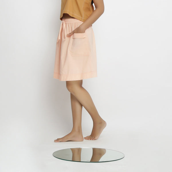 Left View of a Model wearing Powder Pink Vegetable Dyed Cotton Elasticated Mid-Rise Short Skirt