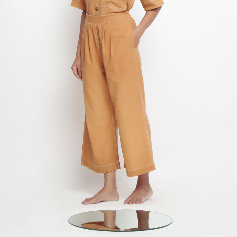 Left View of a Model wearing Rust Vegetable Dyed Cotton Elasticated Wide Legged Pant