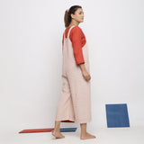 Back View of a Model wearing Ecru and Brick Red Striped Vegetable Dyed Cotton Pinafore Jumpsuit