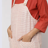 Front Detail of a Model wearing Ecru and Brick Red Striped Vegetable Dyed Cotton Pinafore Jumpsuit