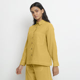 Left View of a Model wearing Vegetable Dyed Yellow Button-Down Cotton Top
