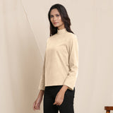 Left View of a Model wearing Warm Beige Turtle Neck Straight Top