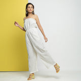 Left View of a Model wearing White Cotton Schiffli Floral Elasticated Tube Neck Jumpsuit