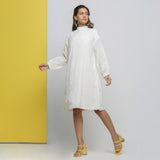 Left View of a Model wearing White Floral Cotton Schiffli Knee Length Stand Collar Dress