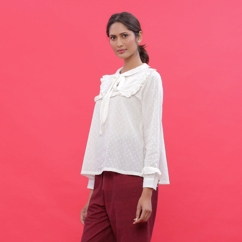 Left View of a Model wearing White Dobby Ruffled Peasant Blouse Top