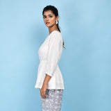 Left View of a Model wearing White Organic 100% Cotton Round Neck Peplum Top
